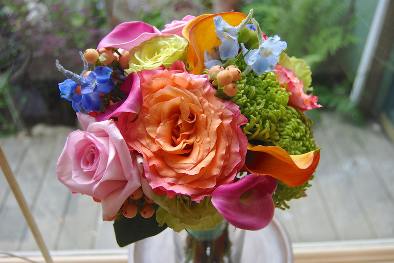 A lush bouquet of coral roses, peonies and calla lilies